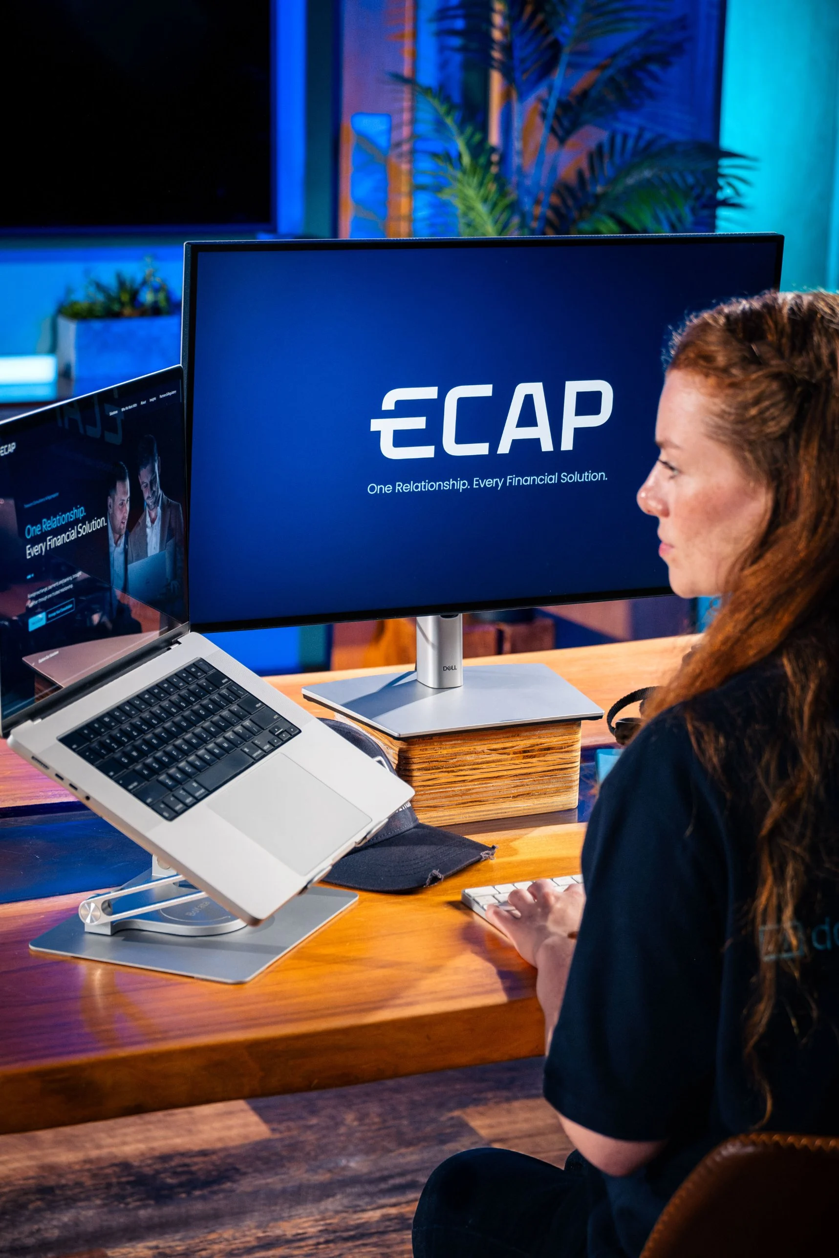 Ella Garvey at a desk with the ECAP logo on a large screen