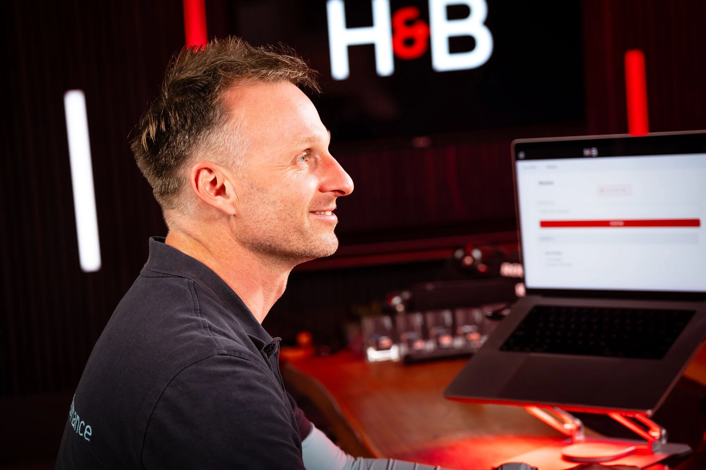 John Beaty smiling at a laptop running the H&B app in the DotPerformance studios