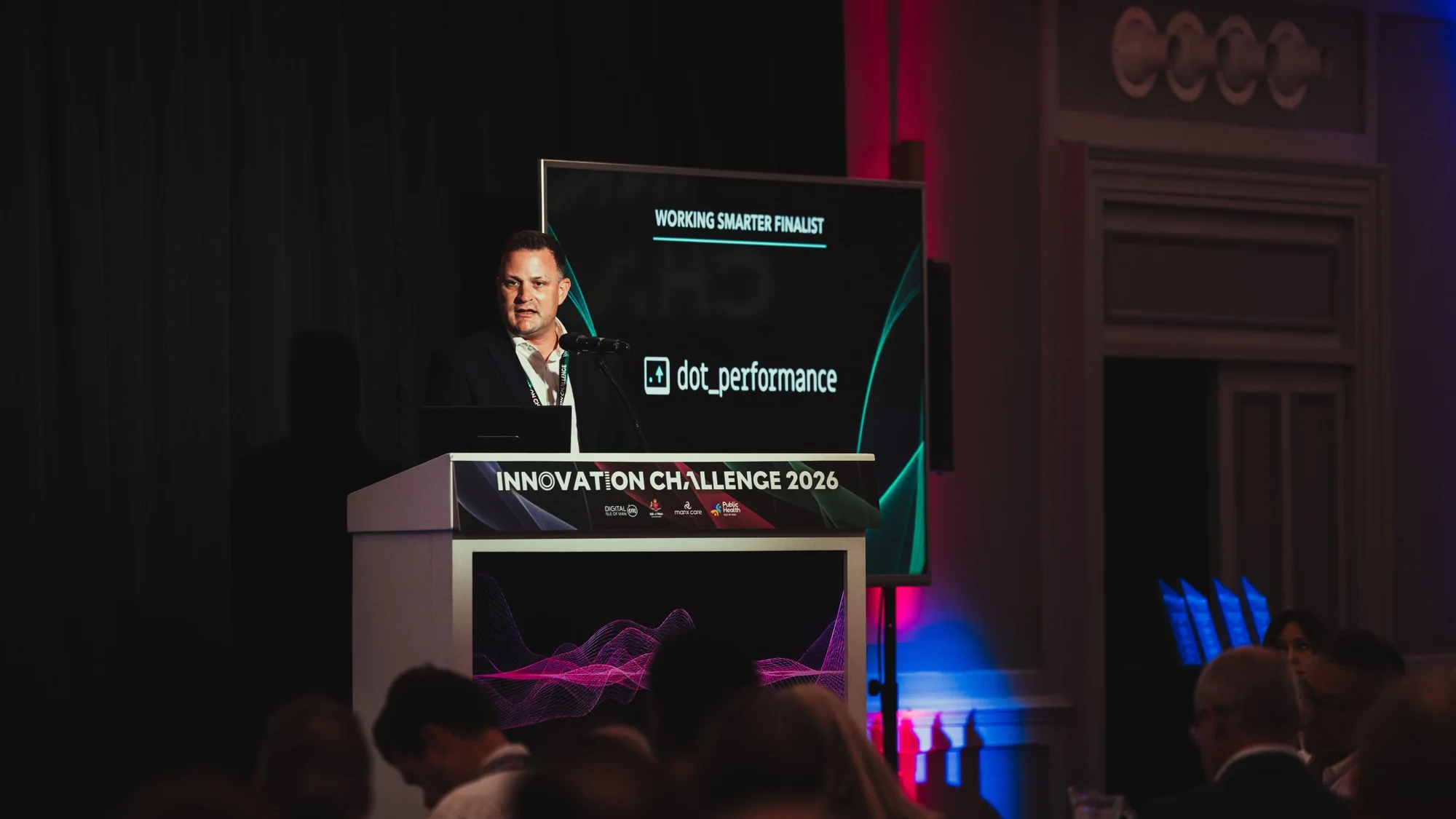 Andy Orton at the lectern as DotPerformance is introduced as a Working Smarter finalist at Innovation Challenge 2026