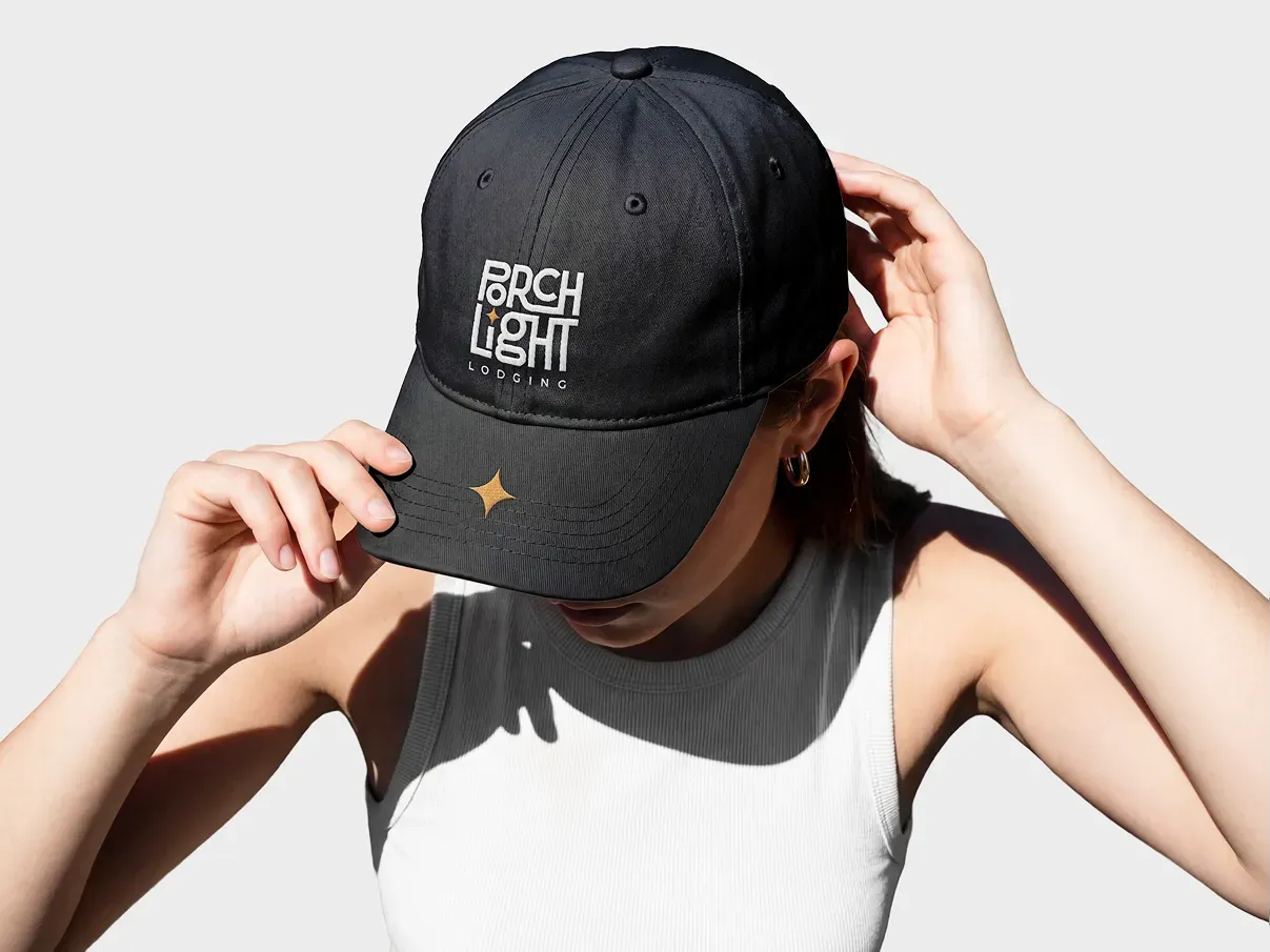 A woman in a black PorchLight Lodging cap, from the PorchLight identity